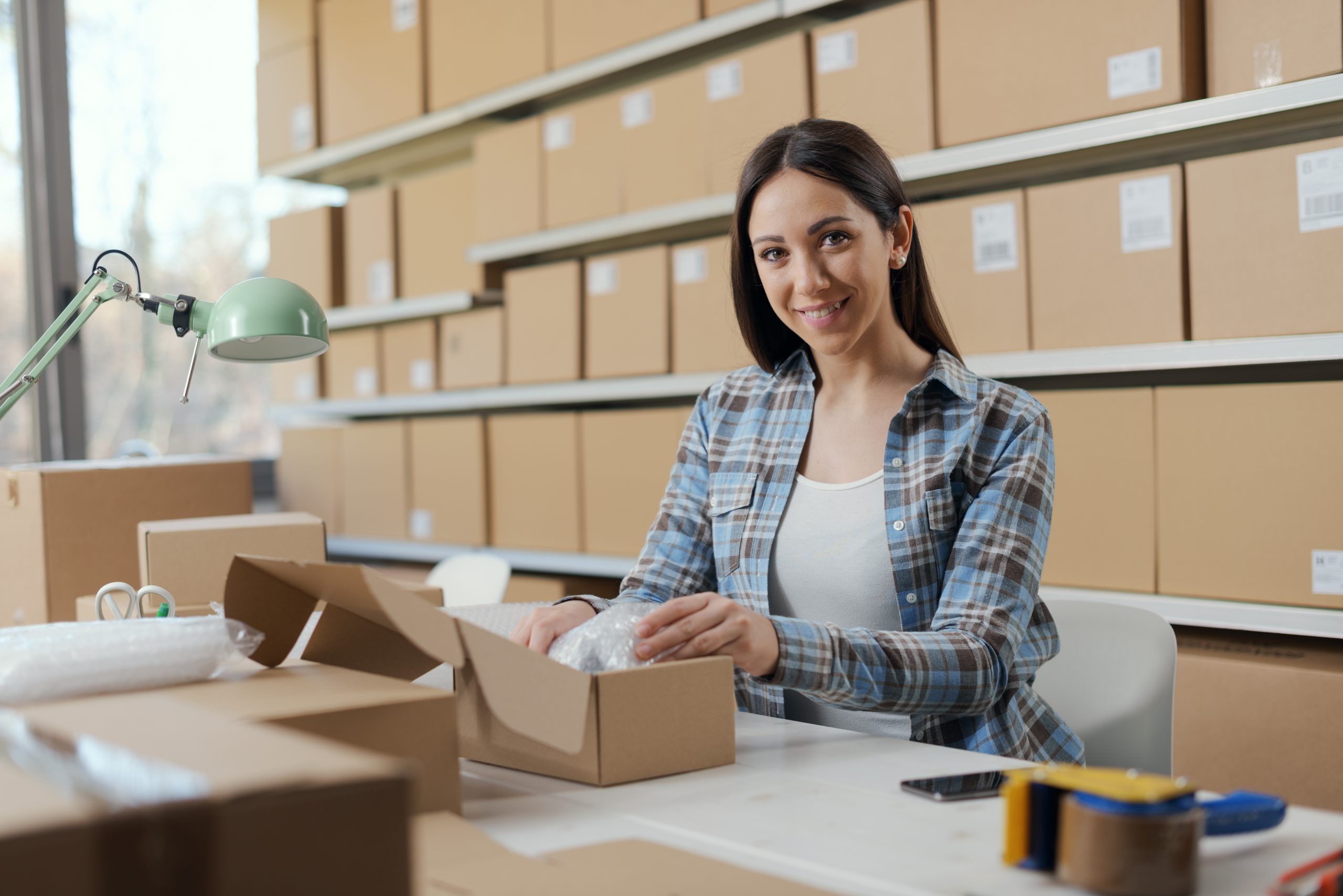 Happy,Woman,Putting,Items,In,A,Delivery,Box,And,Preparing